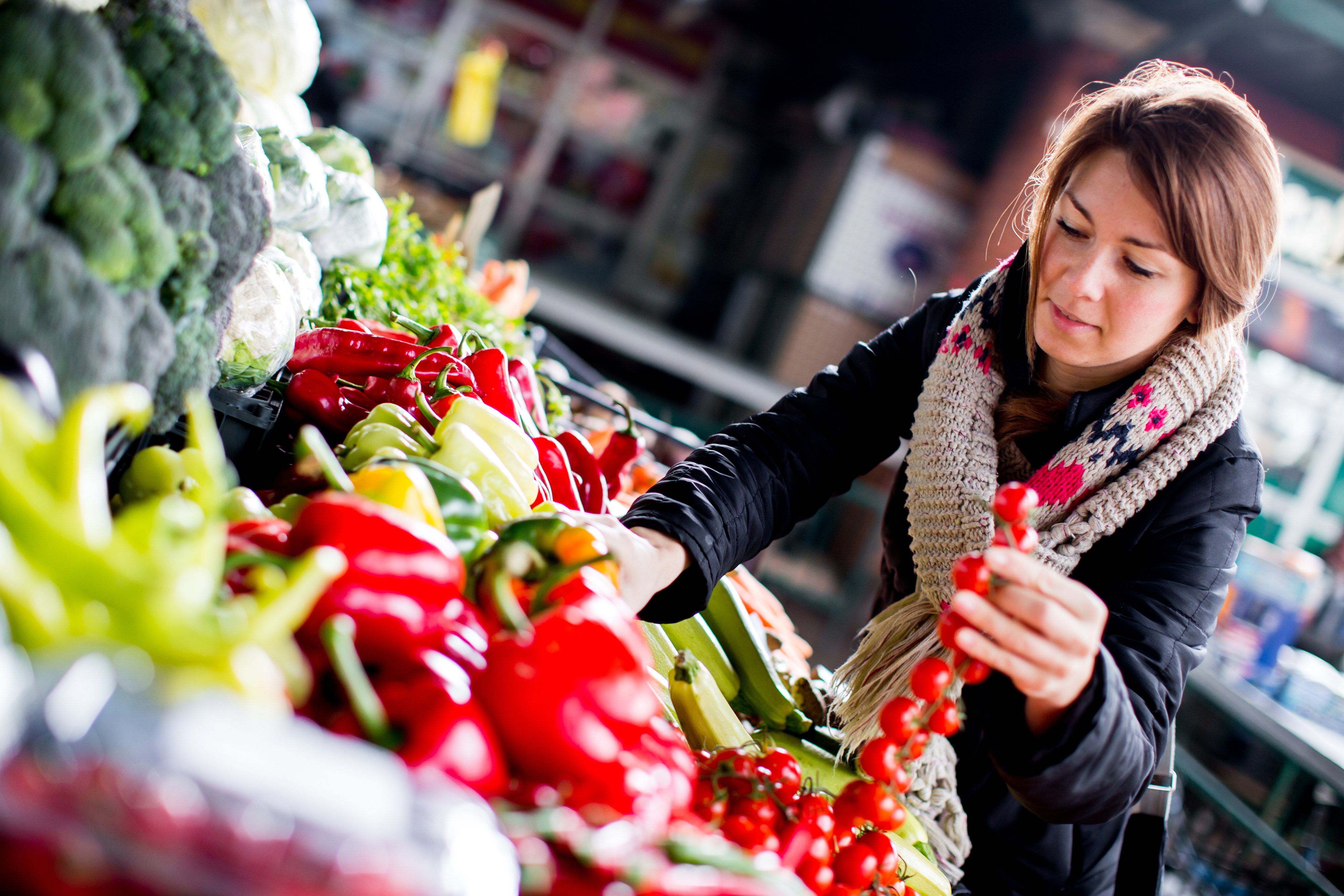 Kvinna som köper ekologiska frukter och grönsaker. 